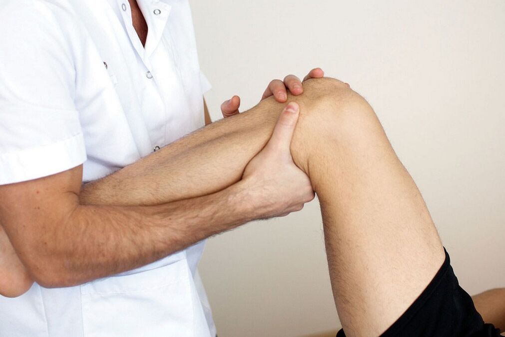 liječnik pregleda koljeno s artrozom